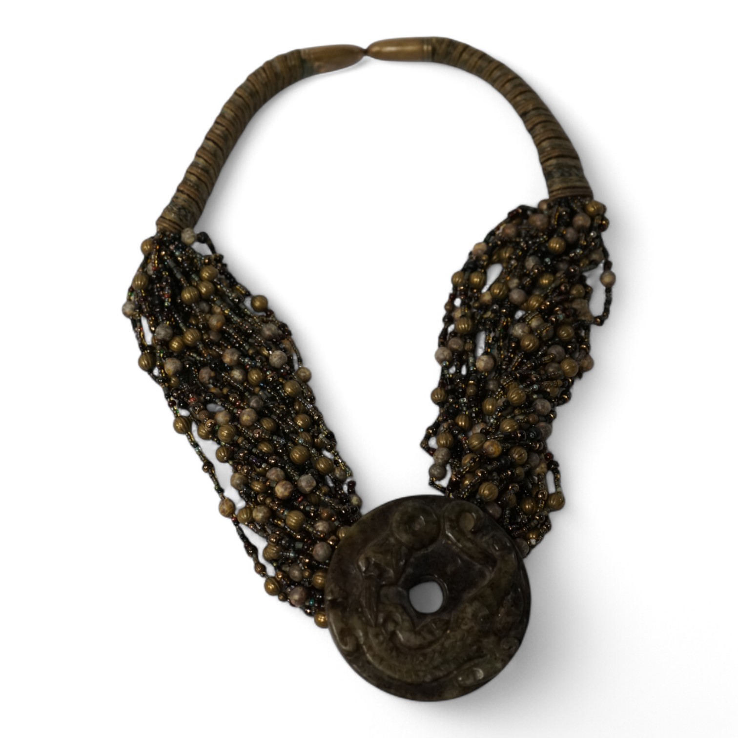 A Chinese multi bead necklace with carved bowenite ‘dragon’ pendant, disc 6cm in diameter. Condition - fair to good